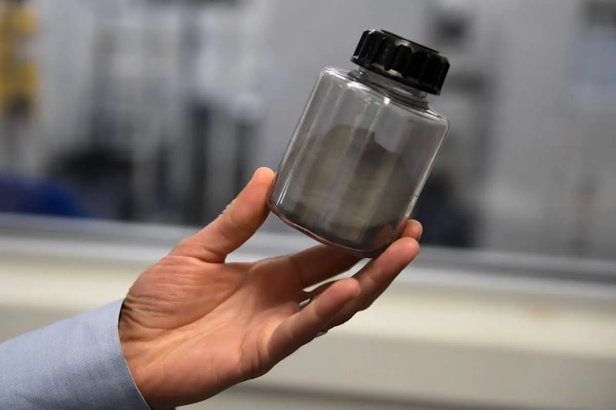 A small transparent canister of powder is shown.