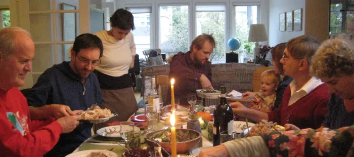 Photo of multi-generational family eating at a dinner table.