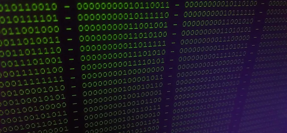 A digital screen displays binary code.