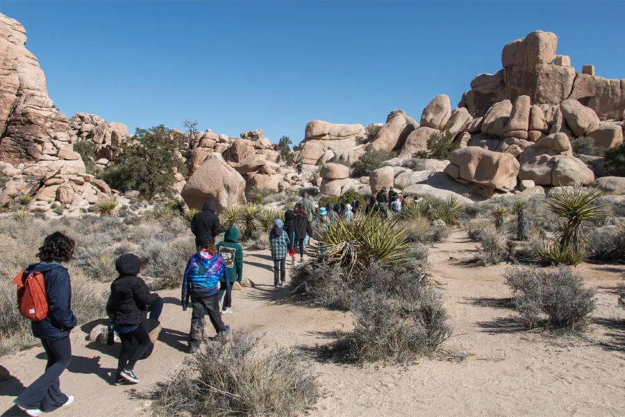 Photo of children on a hike in a rocky, sandy area.