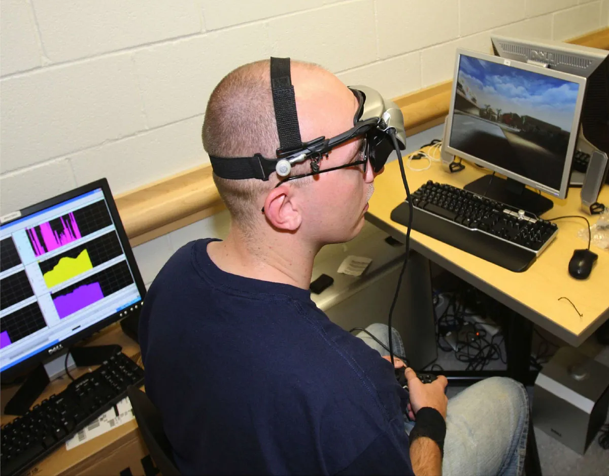 Person sitting at computer wearing biofeedback monitoring device