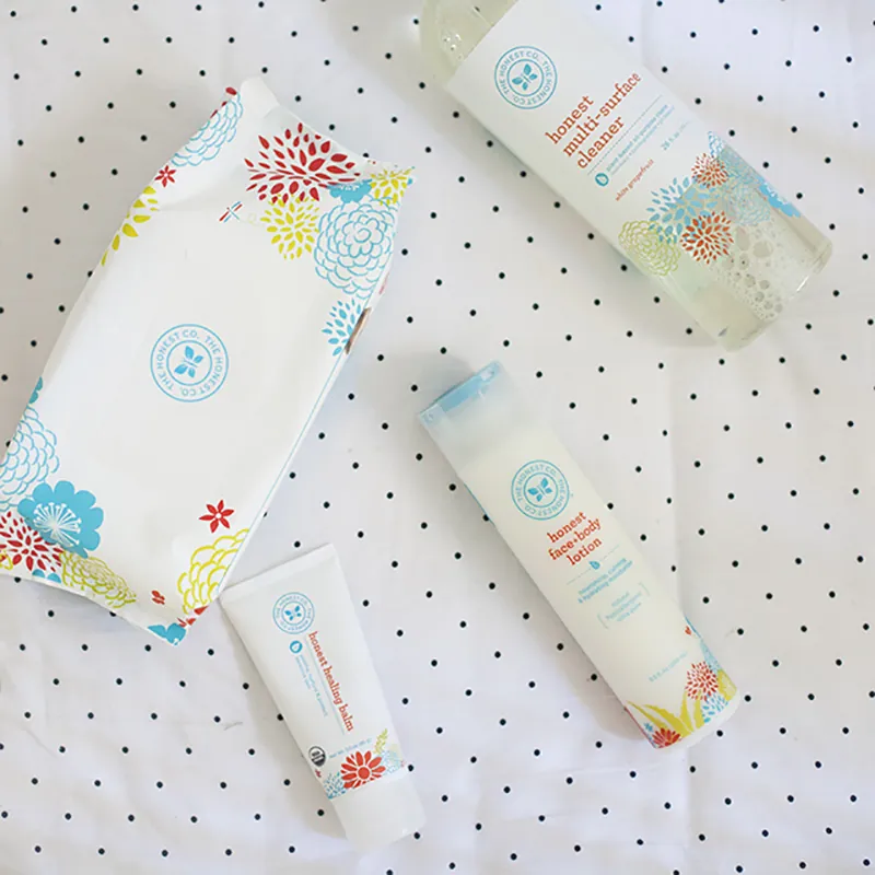Baby wipes, healing balm, face-body lotion, and multi-surface cleaner from Jessica Alba’s Honest company are arranged on a blanket.