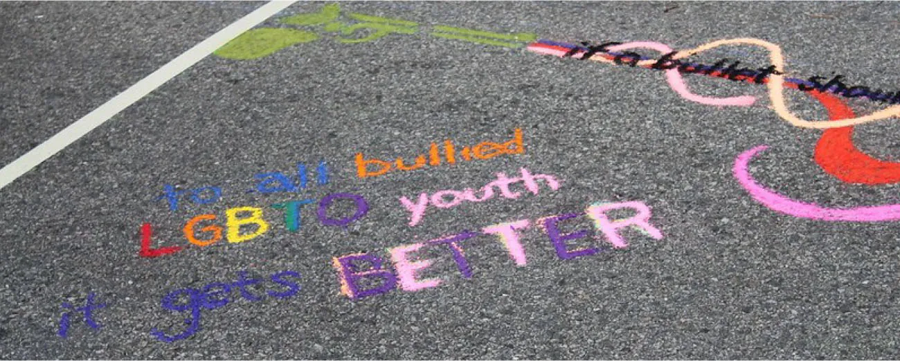 Photo of chalk drawing on sidewalk with lettering: to all bullied LGBTQ youth  it gets BETTER