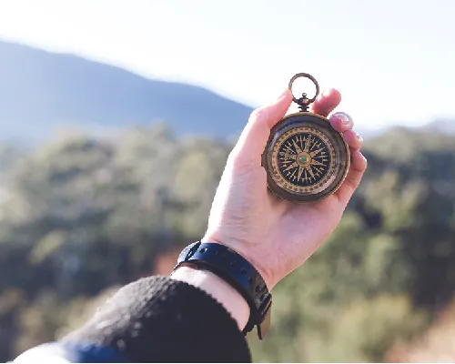 Photo of a hand holding a compass.