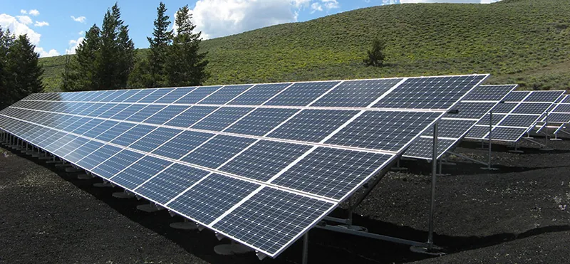 Rows of solar panels lined up in an open space.