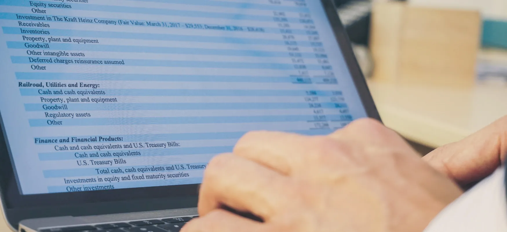 A laptop screen displays line items of a financial statement.