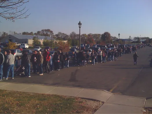 An image of a large group of people lined up along a sidewalk.