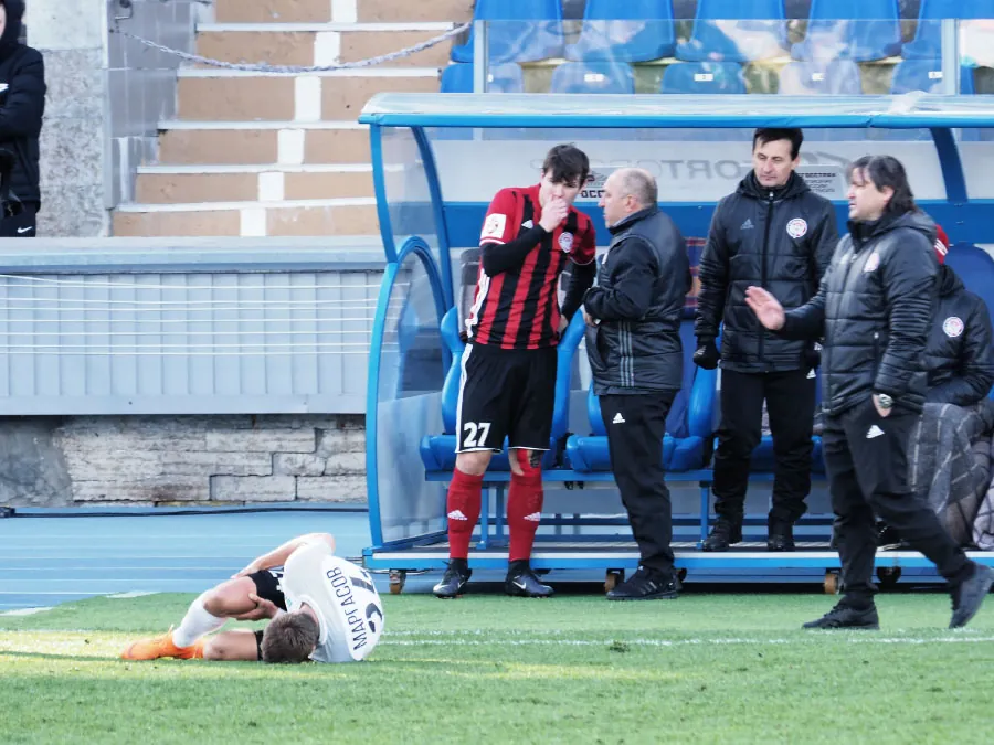 A color photograph shows an injured soccer player laying on the field.