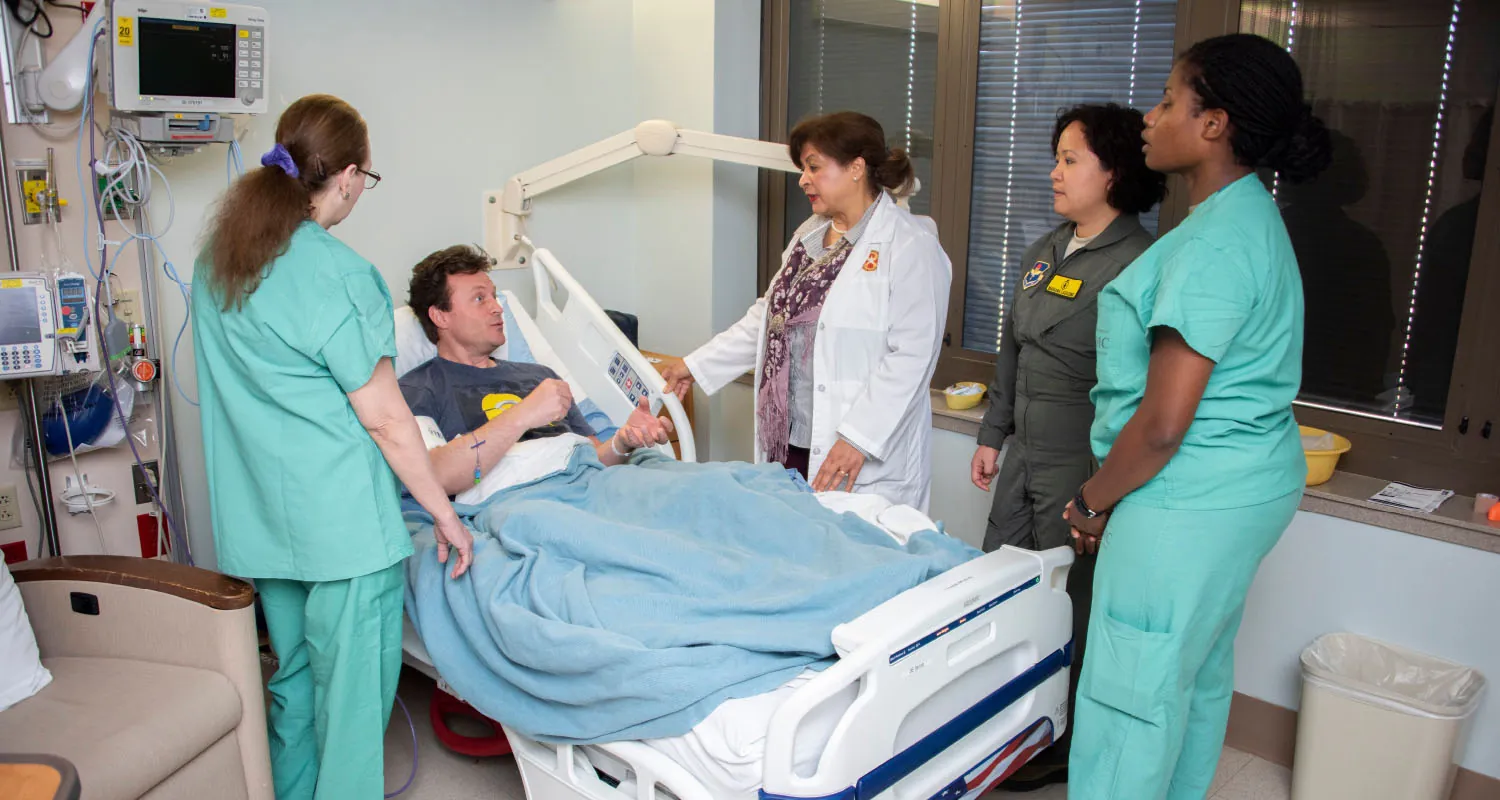 Healthcare providers speaking to patient in hospital bed