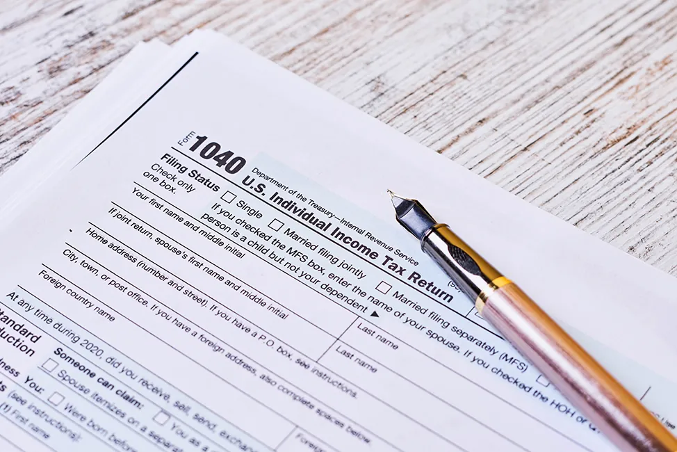A pen is placed above the income tax return form.