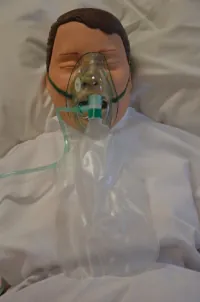 An image of a person’s face with a non-rebreather mask.