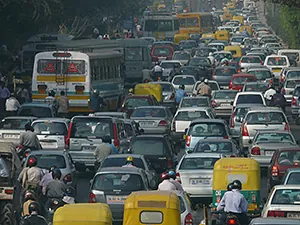 Multiple lanes of traffic crowd a busy street.