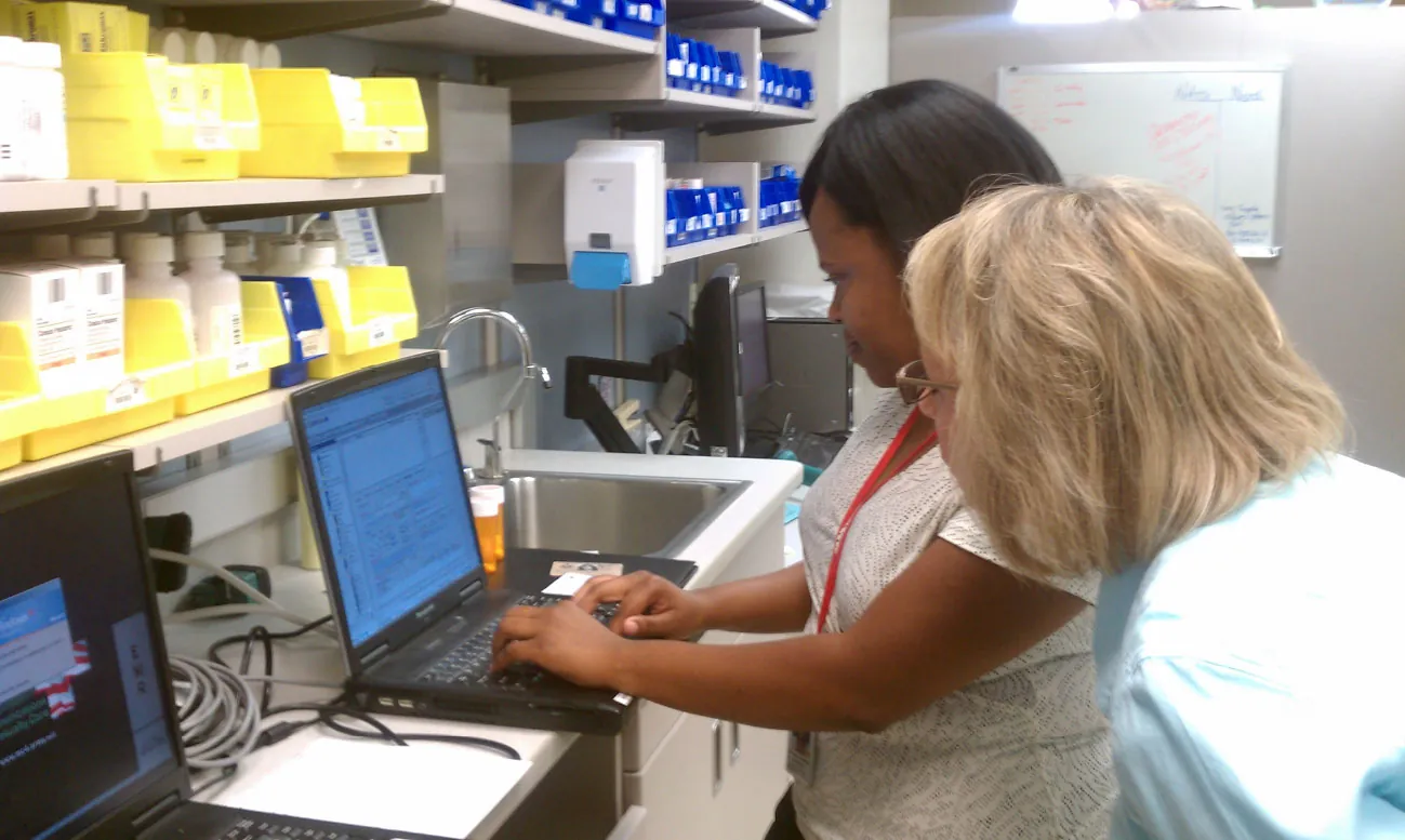 A photograph shows a healthcare provider updating electronic health record.