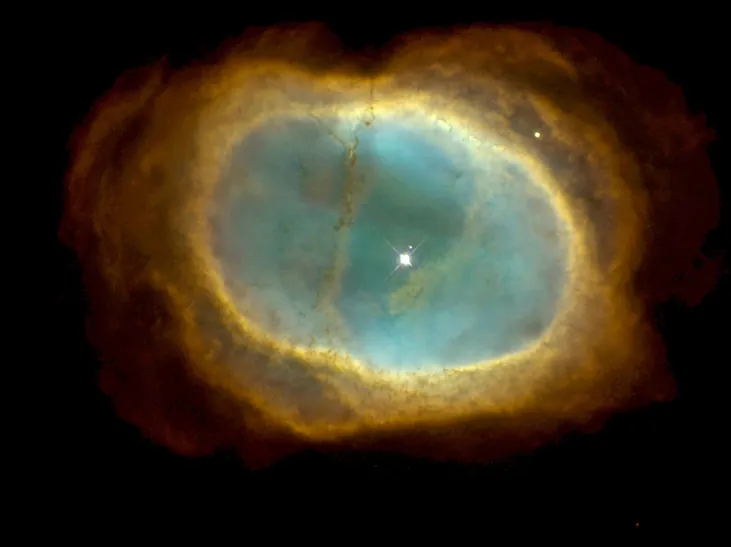 Se observa una mancha verdosa sobre un fondo negro. Sus bordes son amarillentos. En su interior se ve una estrella blanca y brillante.