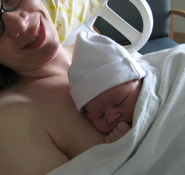 Photo of newborn on mother’s body in a hospital.
