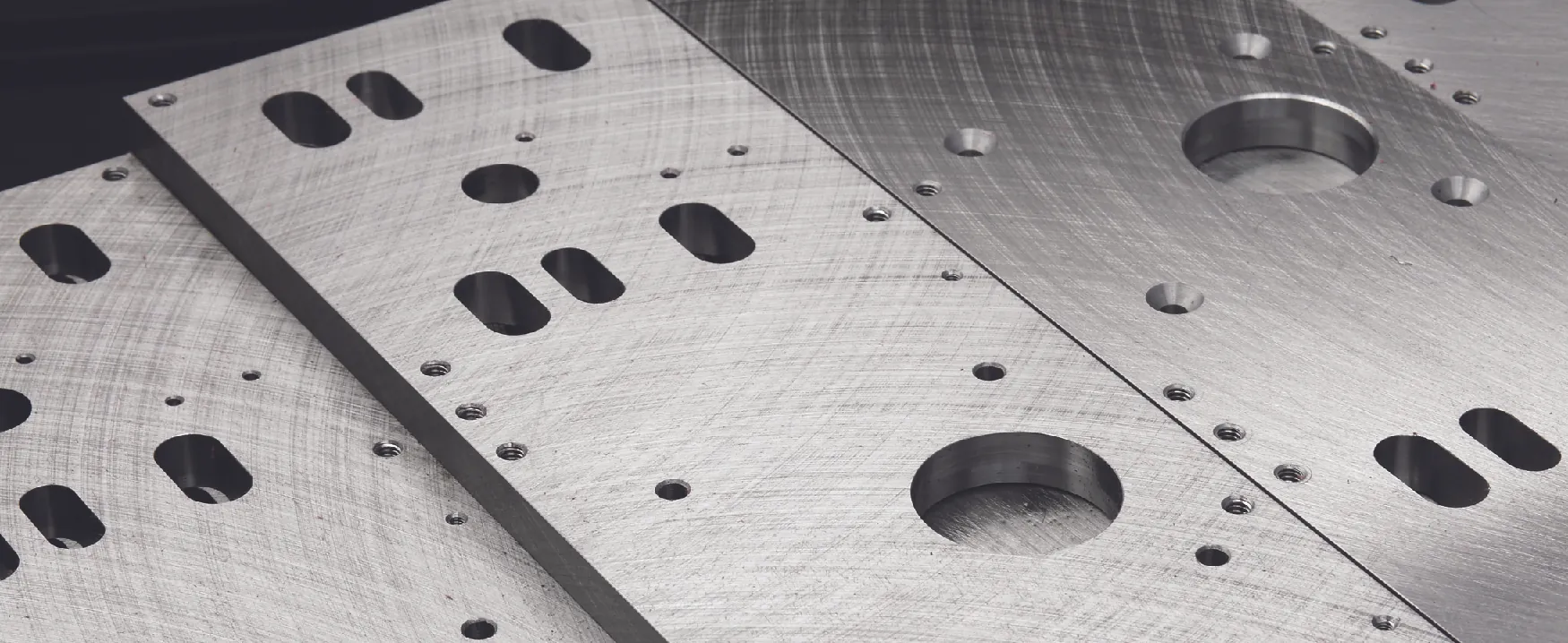 A picture of precision machined metal plates with many holes of differing sizes.
