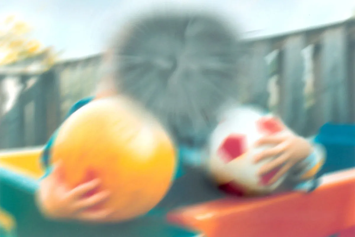 A very blurred photo of two kids, with a dark spot in the center.