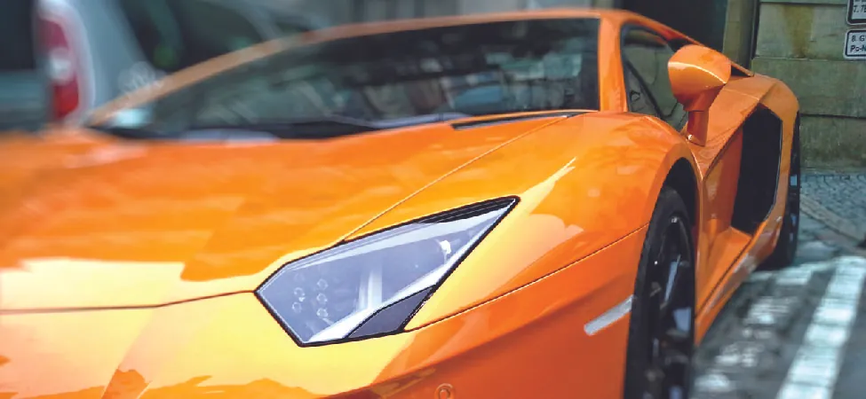 A close up photo of a bright orange Lamborghini Aventador.