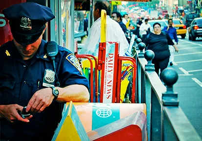 This photo is a police officer looking down at his phone and texting while on duty