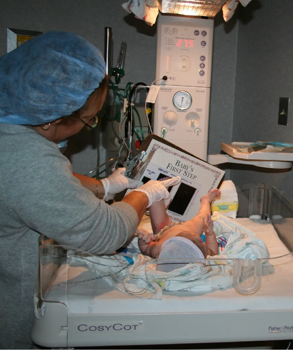 Nurse performing an assessment of a newly born infant.
