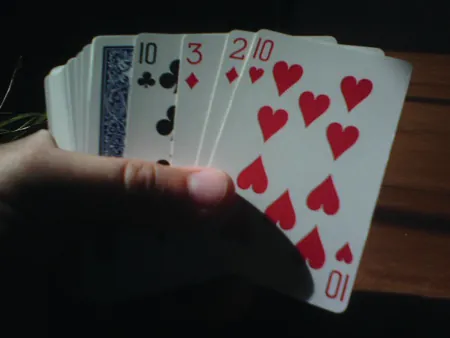 The figure shows someone holding a deck of cards.