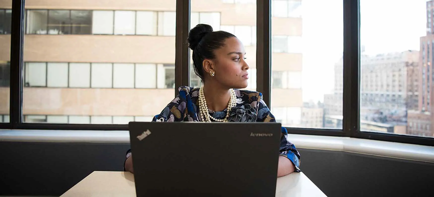 Photo of individual sitting at laptop, looking to their left.