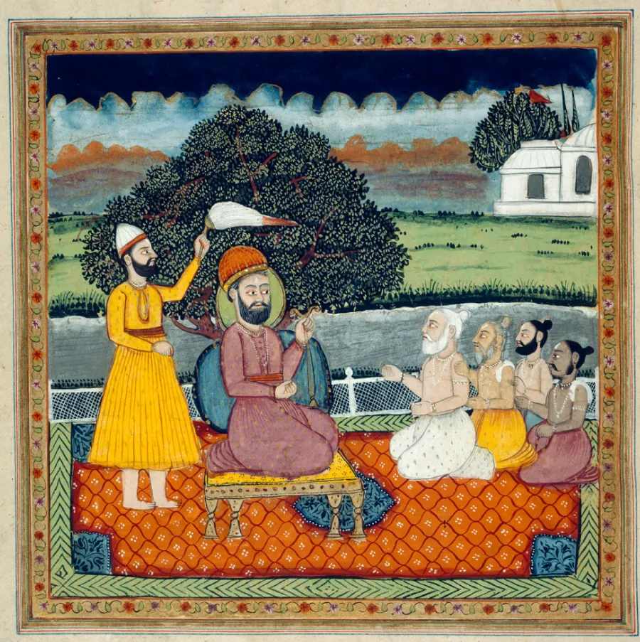 Painting depicting Guru Nanak sitting on a footstool being fanned by a man behind him. Men are kneeling in front of him on an ornate rug. A building and shrubbery is visible in the background.