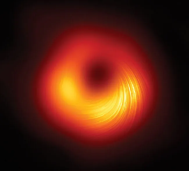 A roughly circular glowing object surrounds a smaller and much darker region. Toward the bottom of the image is a series of several dozen concentric brighter lines.