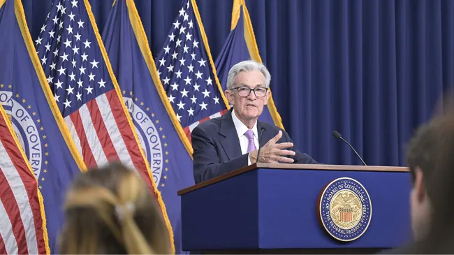A photograph shows Fed Chairperson Jay Powell speaking at a podium.