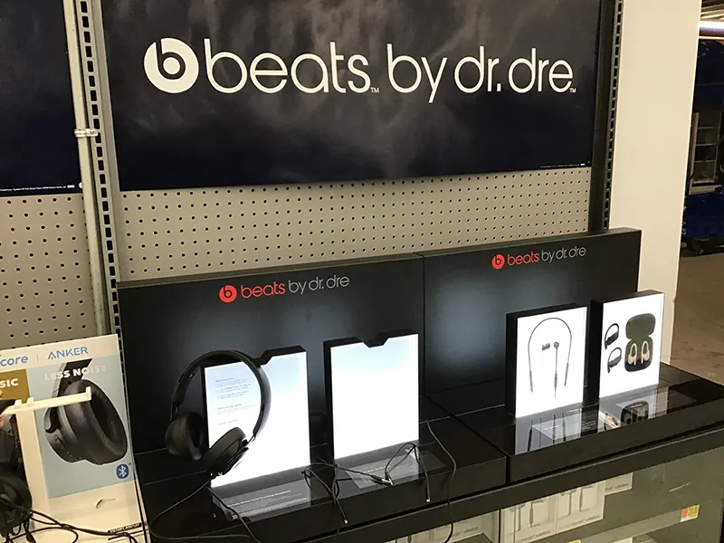 Produkty Beats by Dr. Dre, takie jak słuchawki, głośniki i inne, są eksponowane na wystawie sklepowej.