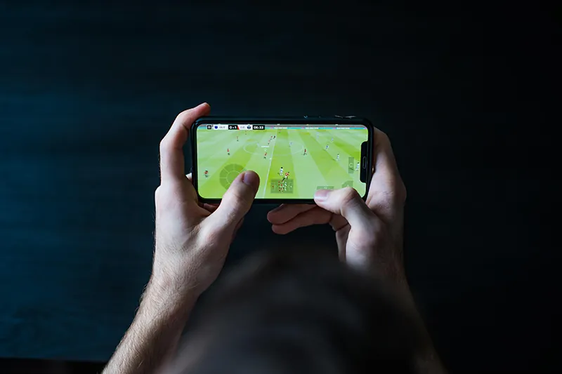 A person plays a video game on a mobile phone.