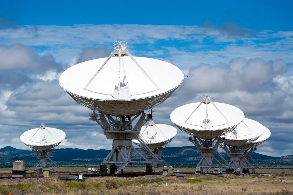 Esta imagen es una foto de radiotelescopios. Tienen grandes cúpulas parabólicas como receptores con una antena en el centro.
