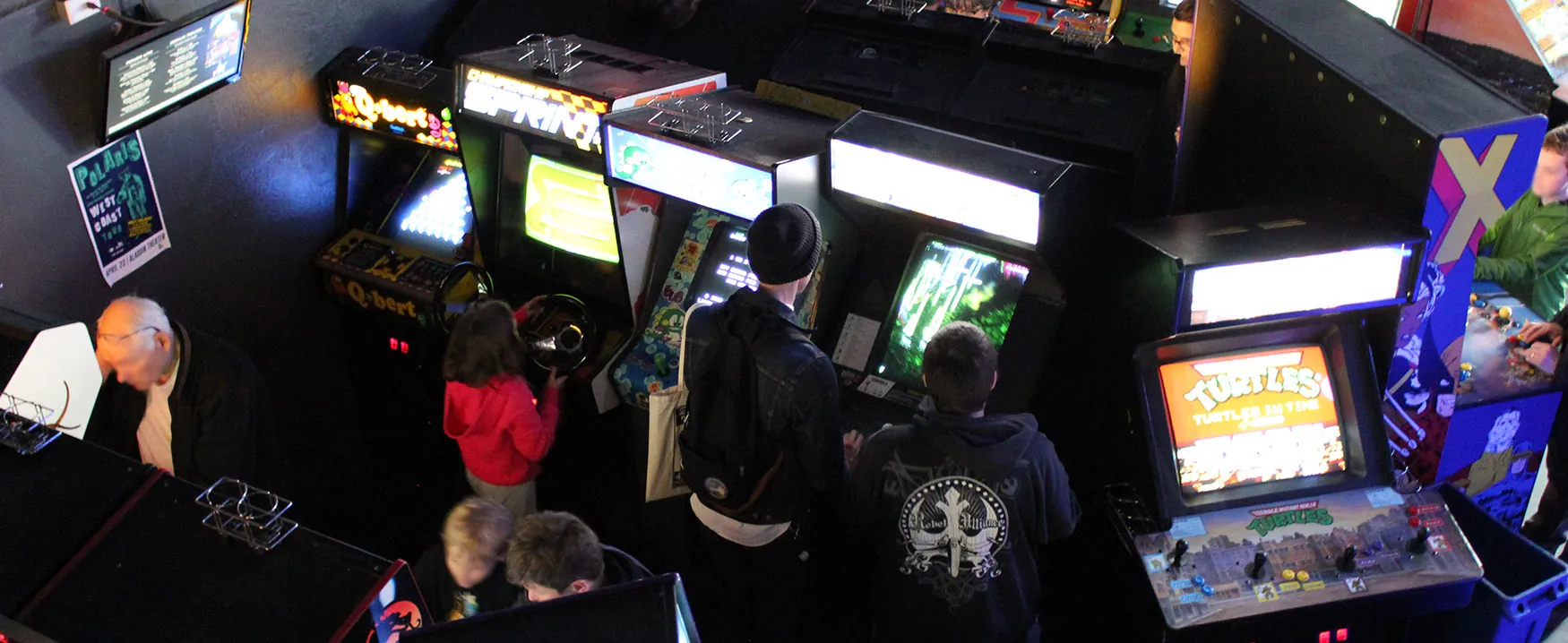 overhead view of arcade games with people playing the games
