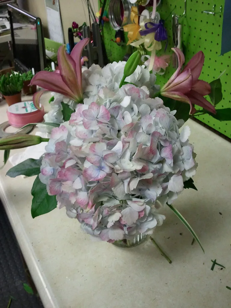 A photograph shows a local florist's workshop with a freshly prepared bouquet of flowers