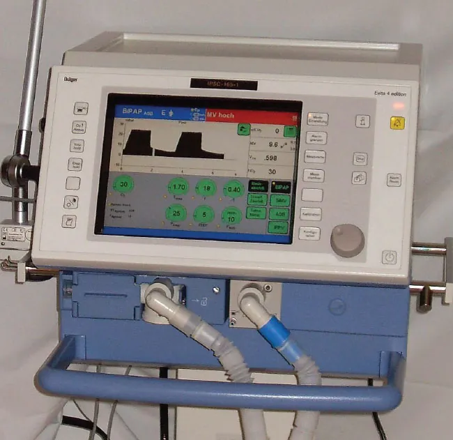 A color photograph of a ventilator showing the front panel and tubes.