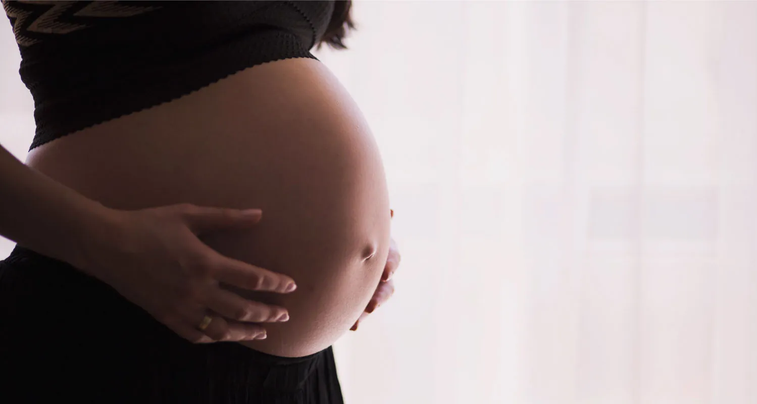 A photograph of a pregnant person’s abdomen