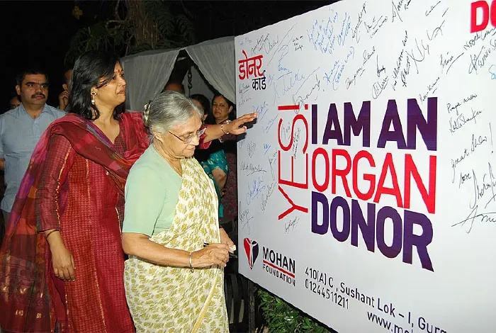 Photo of individuals viewing a Yes! I Am an Organ Donor poster.