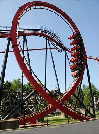 Foto de una montaña rusa con un giro circular vertical. El giro circular tiene una curvatura más cerrada en la parte superior que en la inferior, lo que da una forma de lágrima invertida.