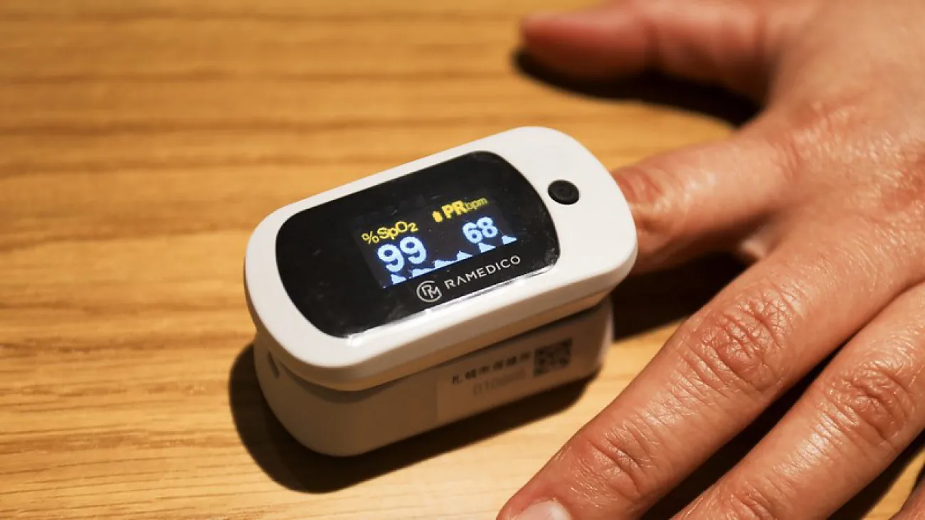 A photo of a person’s finger inside a pulse oximetry device.