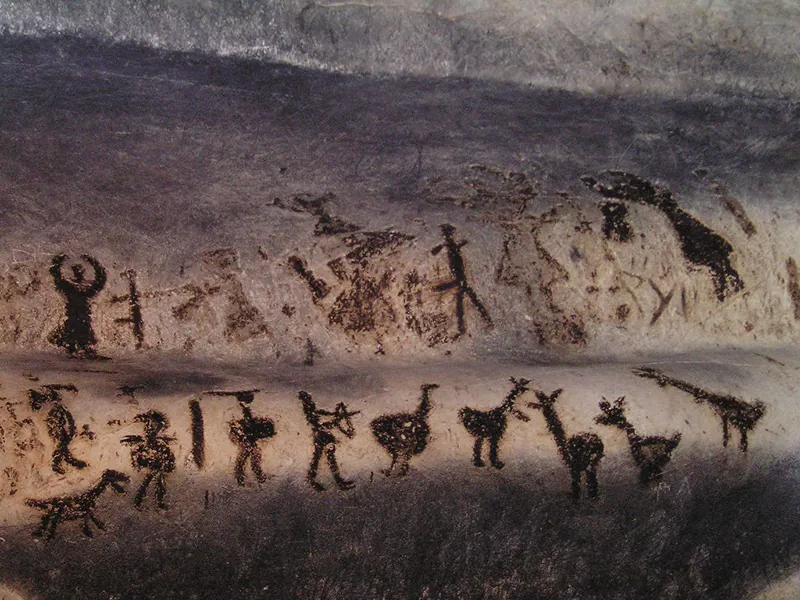 Two rows of abstract figures painted onto a cave wall.