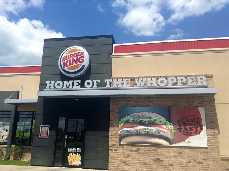 Restauracja Burger King wita gości umieszczonym nad wejściem, pod charakterystycznym logo Burger King, napisem „Home of the Whopper”.