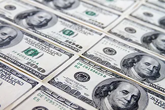 Esta es una imagen de una pila de dinero. Hay billetes de 100 dólares envueltos en grupos de 10.000 dólares