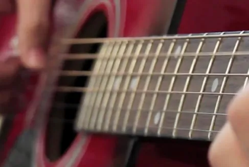 Fotografía de alguien tocando una guitarra.
