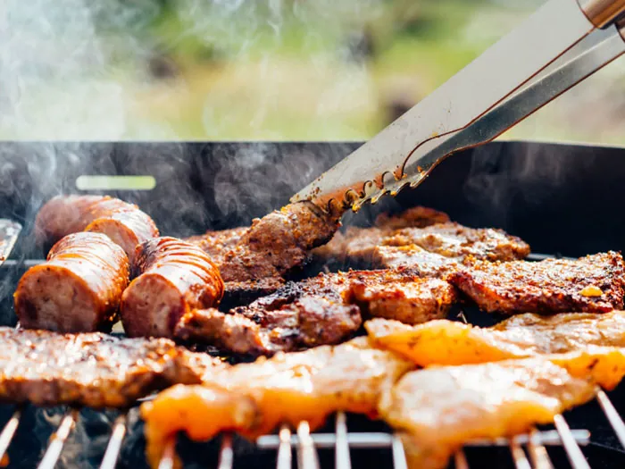 The cooking of meat on a grill.