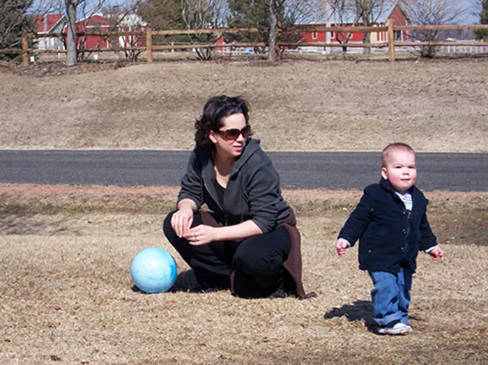 Photo of adult watching young child.